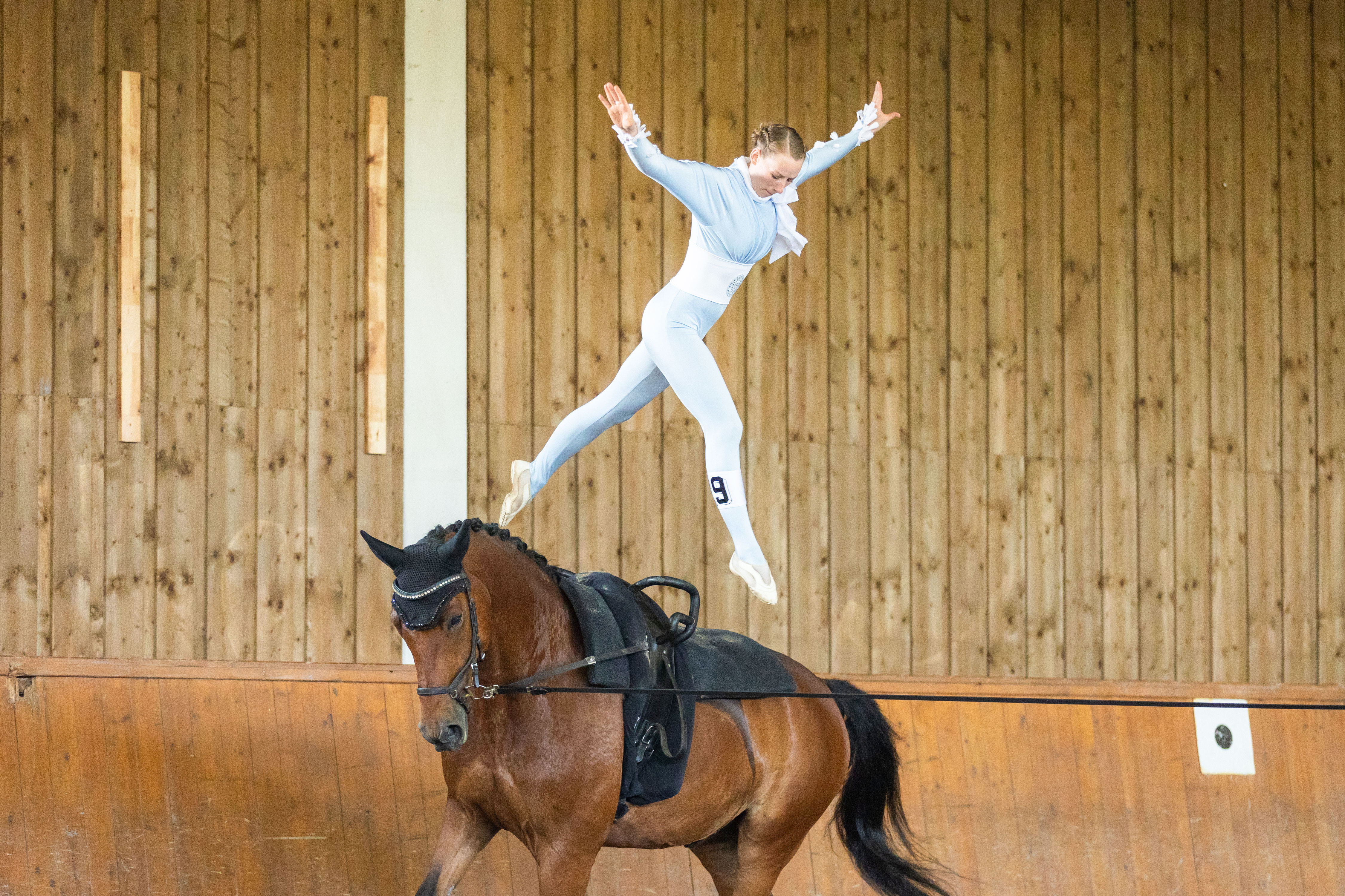 Voltigierendes Mädchen macht einen Sprung auf ihrem Pferd