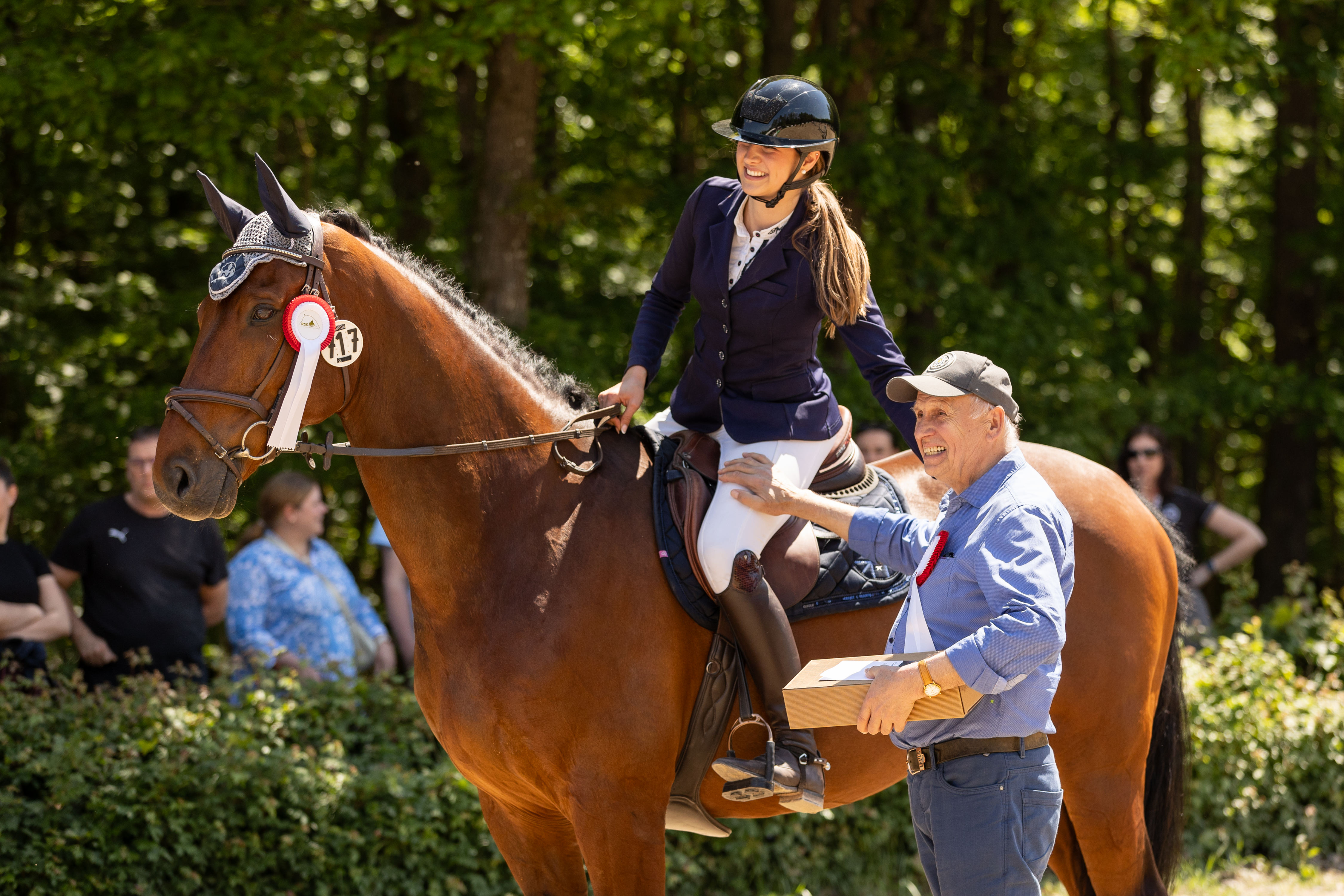 Siegerehrung einer Springprüfung bei den Saarburger Reitertagen, Vater steht neben seiner platzierten Tochter und lächelt