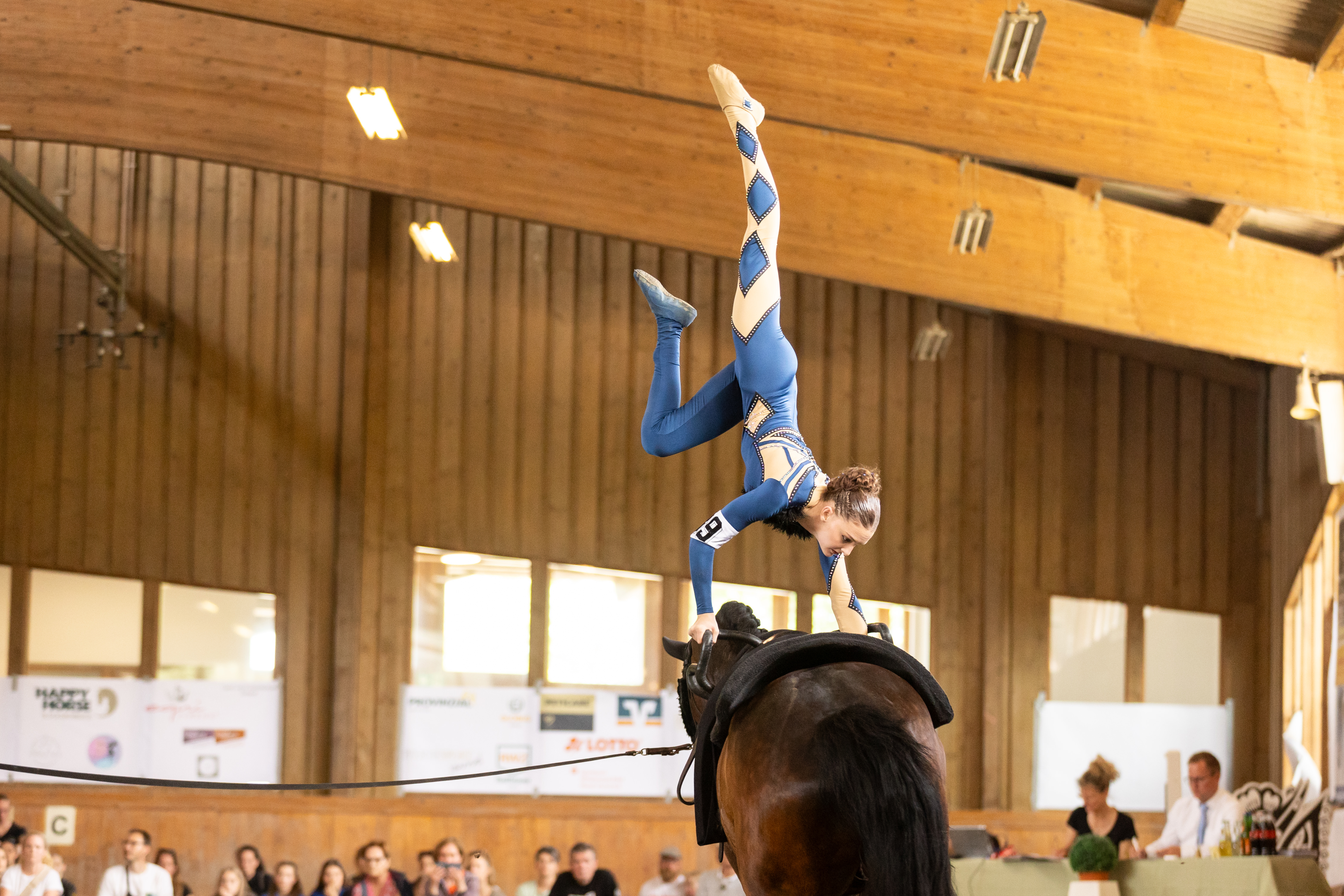 Ein Mädchen voltigiert auf einem braunen Pferd, Voltigierturnier Bernkastel-Kues