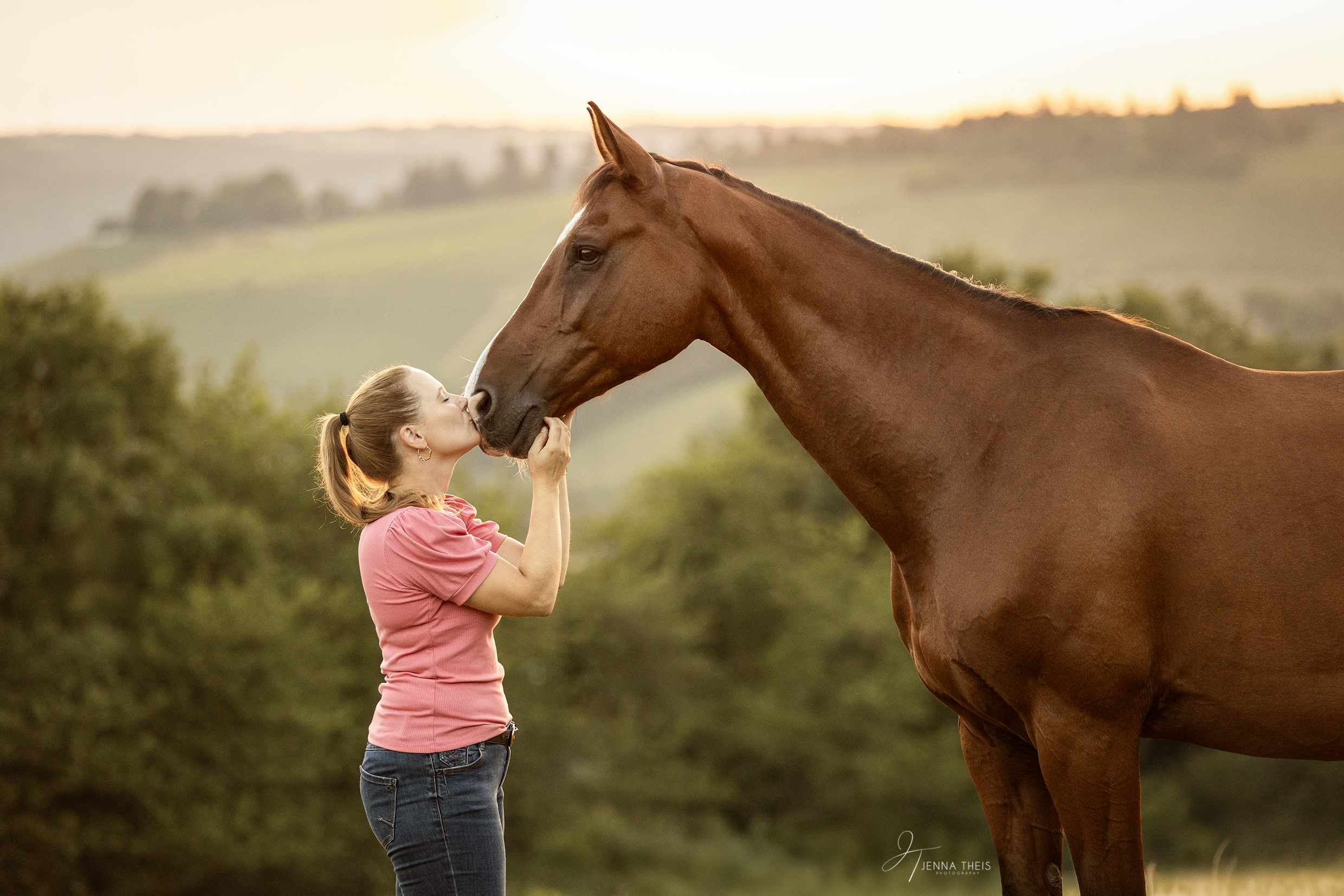 Frau gibt ihrem Pferd einen Kuss auf die Nase